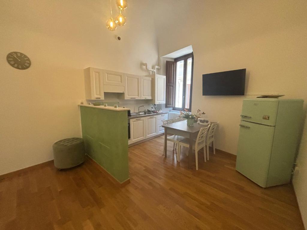 a kitchen with a green refrigerator and a table at La Dimora del Duomo in LʼAquila