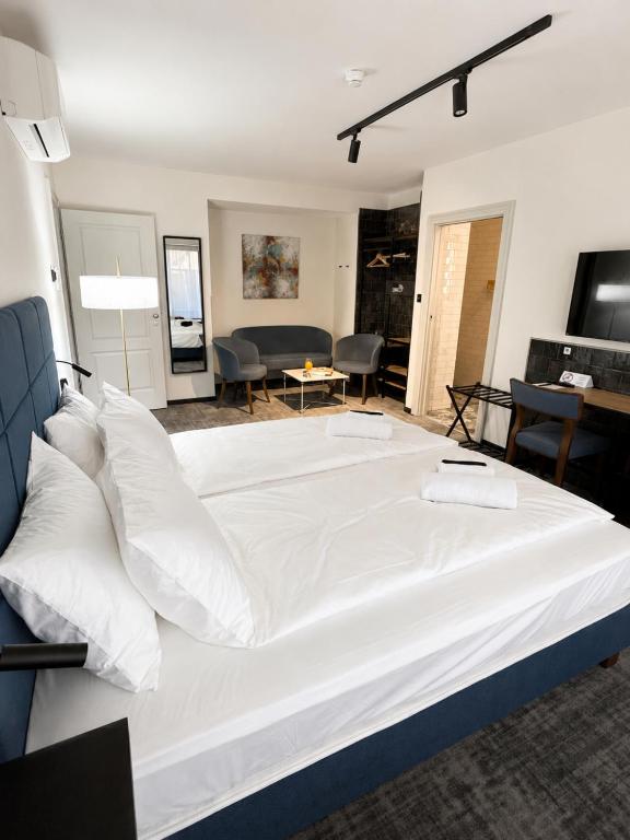 a large white bed in a room with a living room at The 8 Hotel Budapest in Budapest