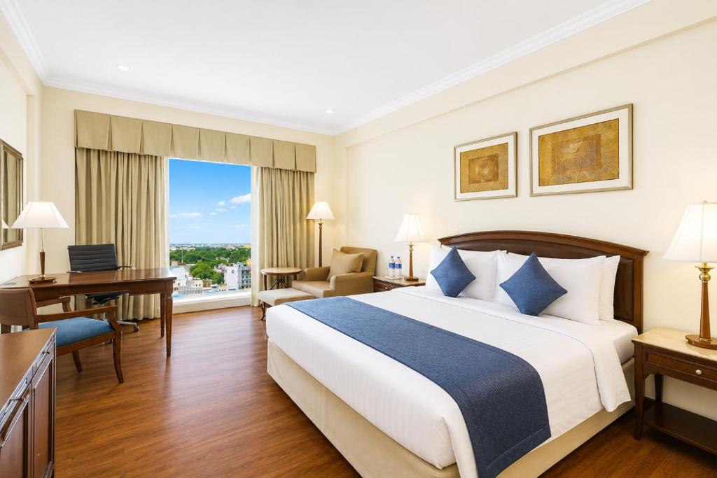 a hotel room with a bed and a desk at Hotel Nirmla Residency in Brahmapur