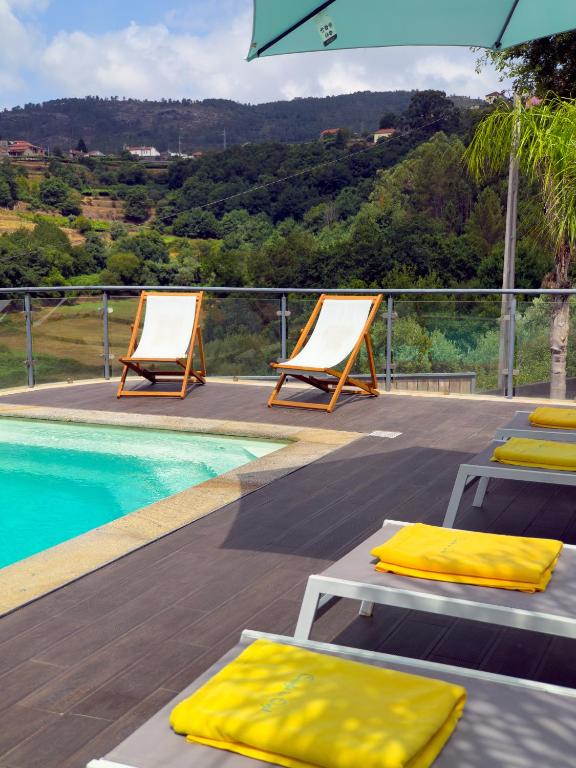 a deck with two lounge chairs and a swimming pool at Casinha do Orjal in Ponte de Lima