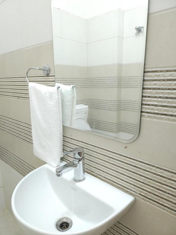 a bathroom with a sink and a mirror at Hotel Kashi Remark Suites By G K Group in Varanasi