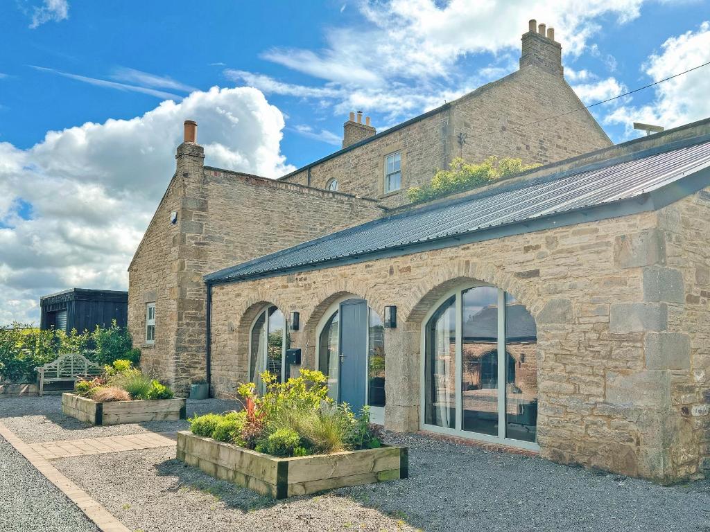 a brick building with a blue door and some plants at The Lodge in Consett