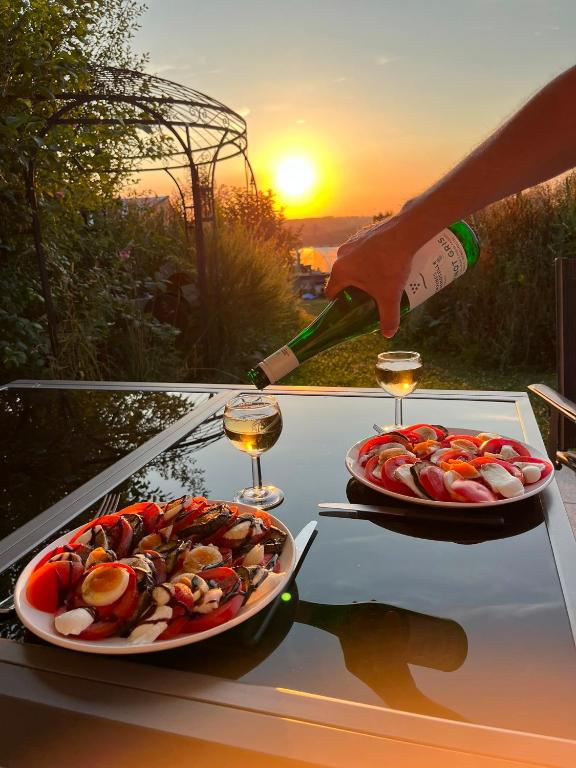 eine Person, die Wein auf zwei Teller mit Essen gießt in der Unterkunft Studio Keppelborn in Sankt Vith