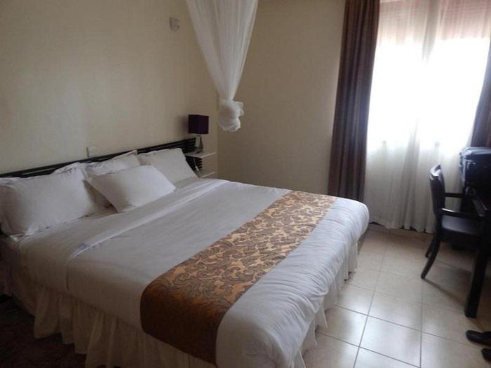 a bedroom with a large bed and a window at Tumaini Guest Home in Gathundia