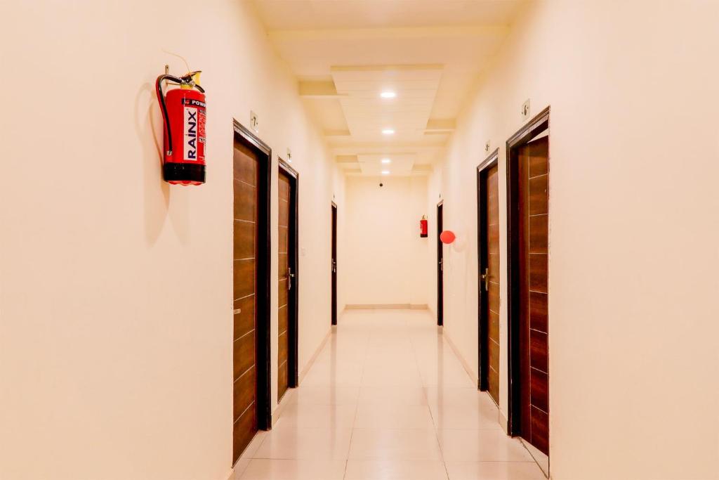 a corridor in a building with doors and a hallway at Hotel O KAILASHA INN in Hasanganj