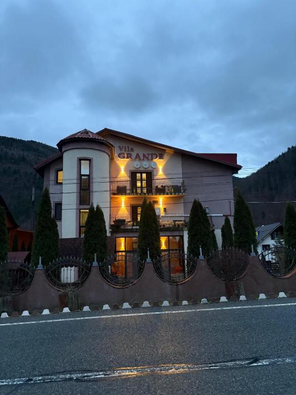 a building with lights on the side of a road at Pensiunea Grande Lepsa in Lepşa