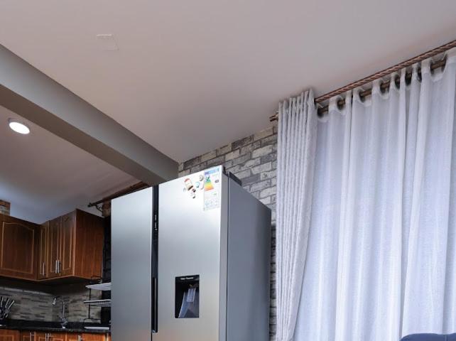 a refrigerator in a kitchen next to a window at Nassiwa Aisha in Kampala