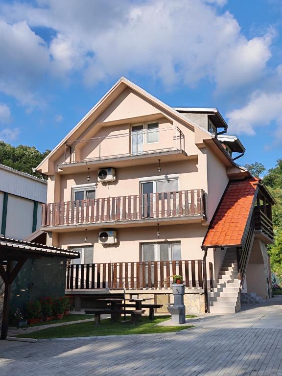 a large house with a balcony and a table at Apartman Ploče in Bajina Bašta