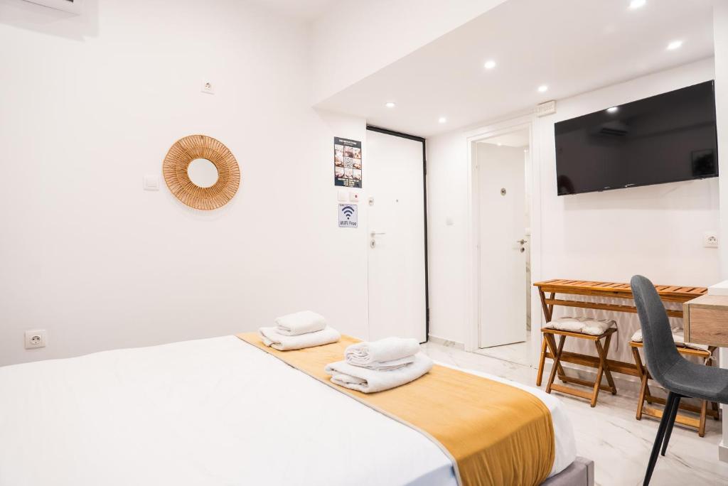 a bedroom with a bed with a desk and a chair at Syntagma Luxury Suites 1 in Athens