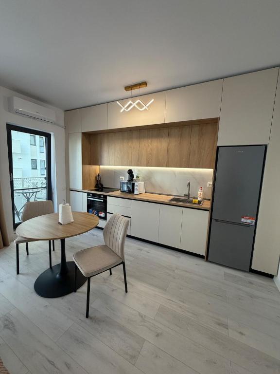 a kitchen with a table and chairs and a refrigerator at Apartament in Ploiesti in Ploieşti