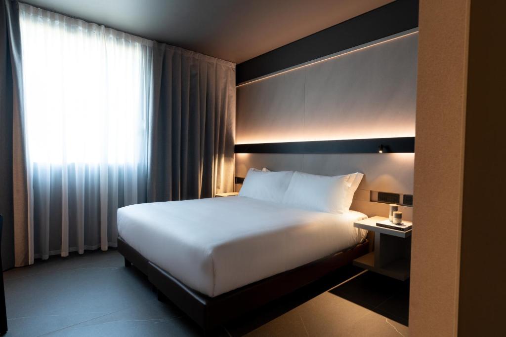 a hotel room with a white bed and a window at Conterraneo Hotel in Marcianise