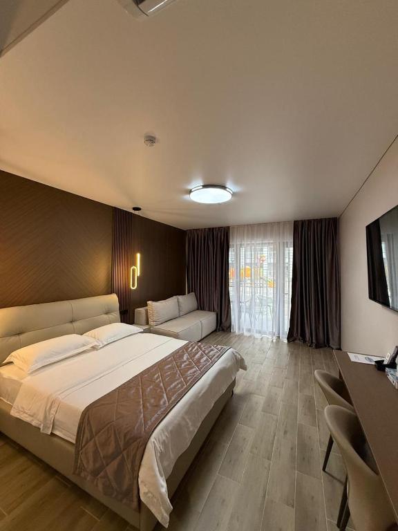 a large bedroom with a large bed and a television at Na More Центр Семейного Отдыха in Kapchagay