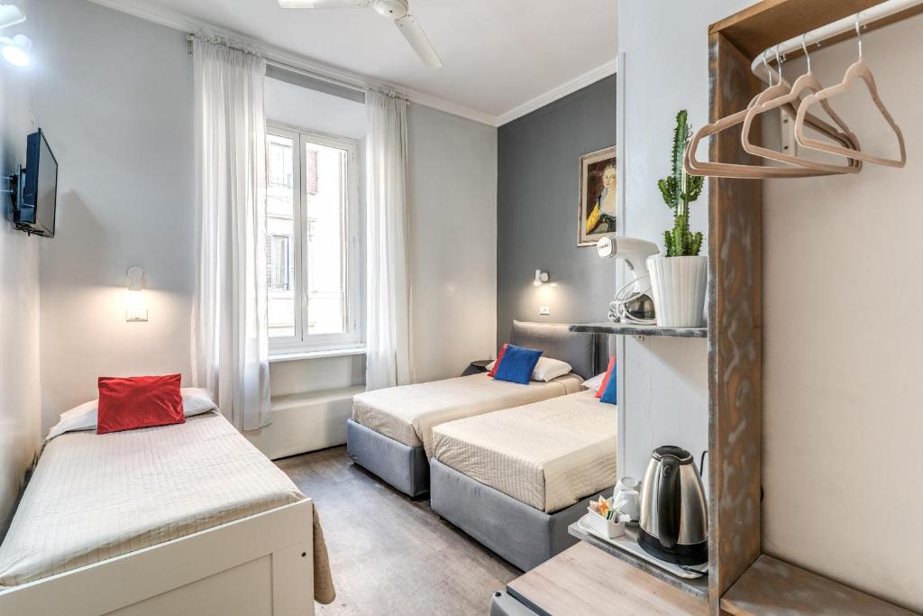 a small room with two beds and a window at Hotel Castelfidardo in Rome