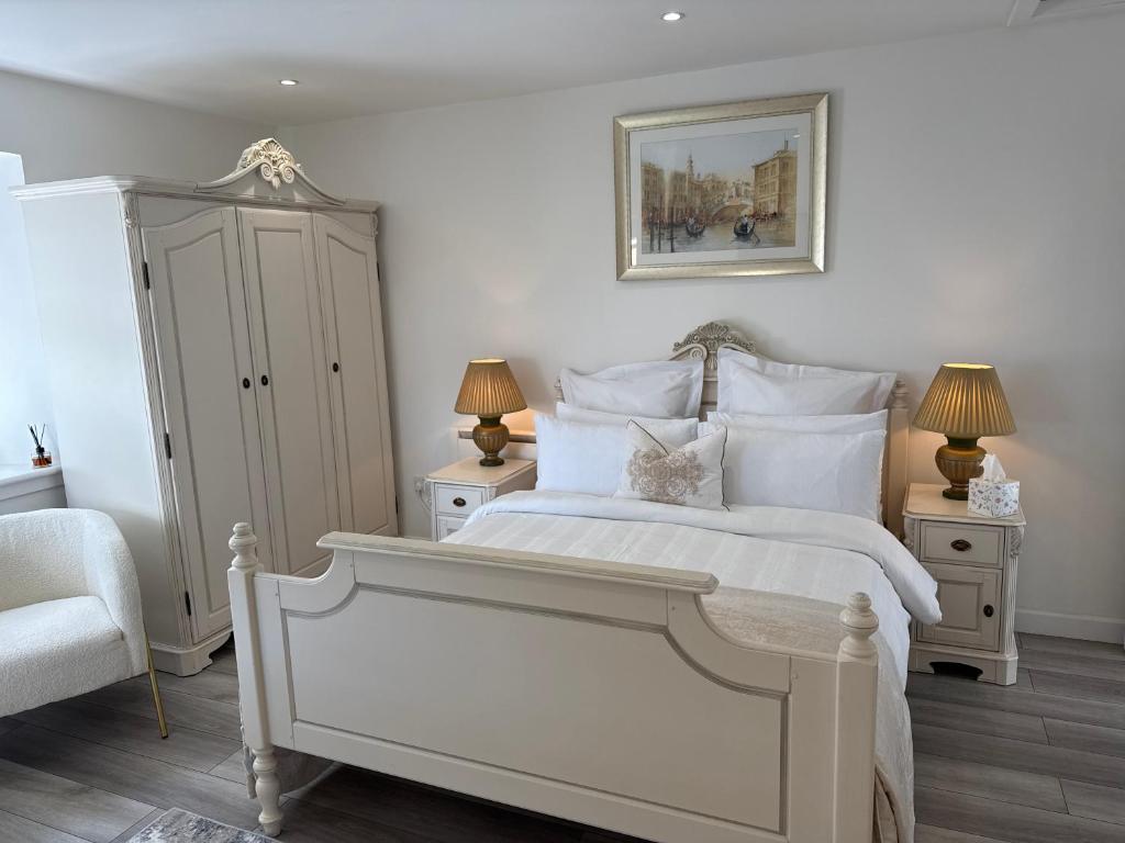 a bedroom with a large white bed with two night stands at Altons Bothy Guest House in Kinmuck