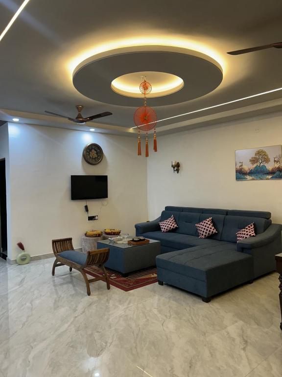 a living room with a blue couch and a tv at Chic & Modern Getaway with Designer Interiors in Jaipur