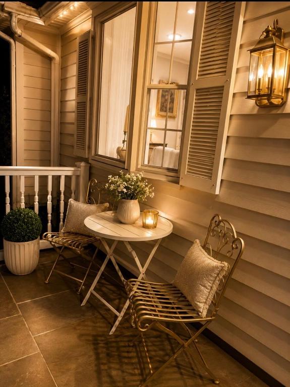 a table and chairs on a porch with a window at Gilded Age Luxury Surrounded by Nature in Norwalk