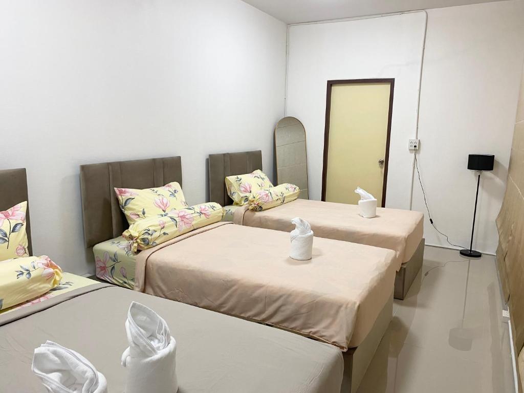 two beds in a room with a mirror at singgah homestay yala2 in Ban Sarong