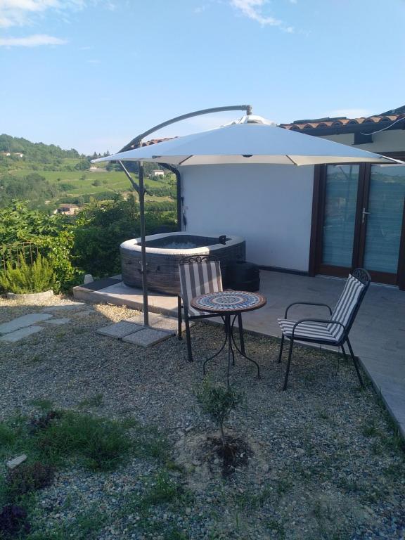 a patio with two chairs and a table and an umbrella at Casa Doris in Montabone
