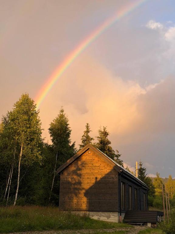a rainbow in the sky over a building at Homin riky in Myta