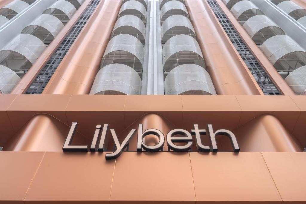 a sign on the side of a building at Lilybeth Hotel Pratunam in Bangkok