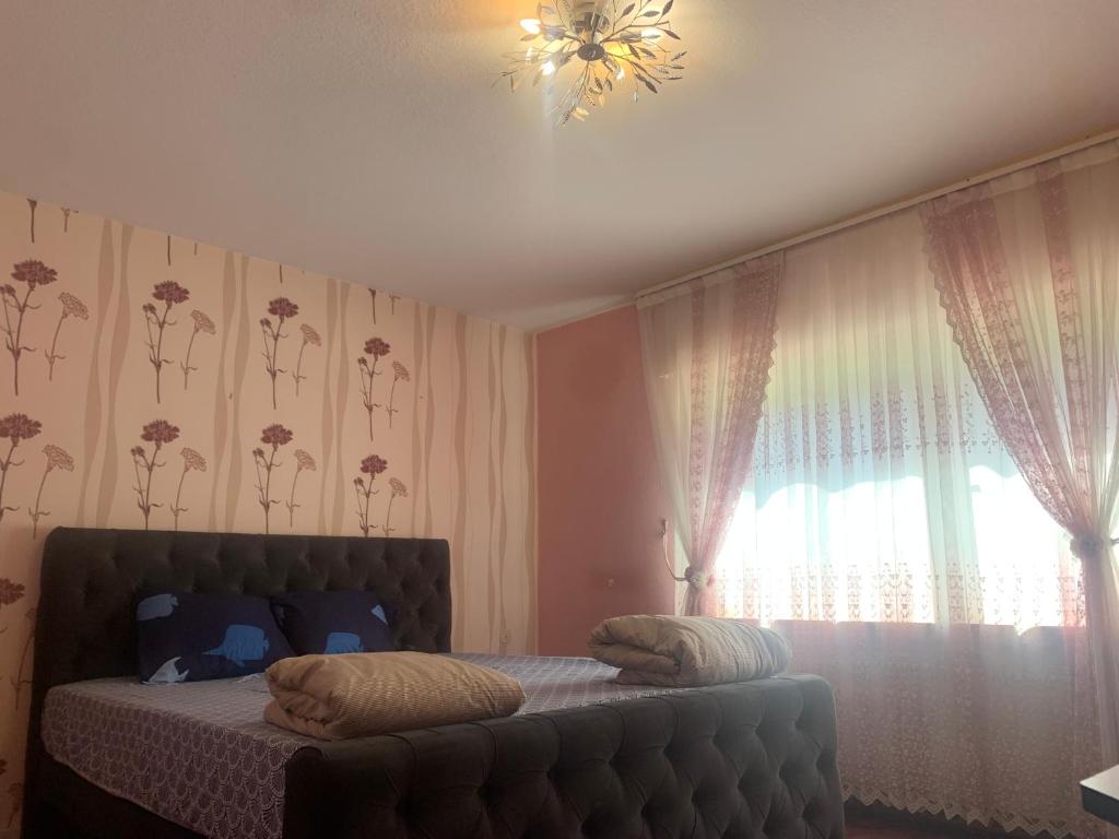 ein Schlafzimmer mit einem Bett und einem Fenster mit Vorhängen in der Unterkunft Haus Tun in Waldbröl
