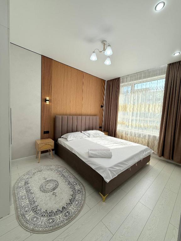 a bedroom with a large bed and a rug at Улы дала in Shymkent
