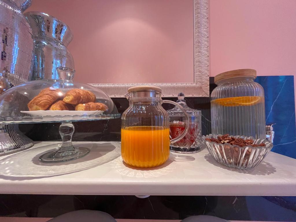 a table with a jug of orange juice and a tray of donuts at Le Palme Di Como in Como