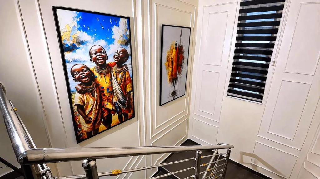 a painting of three apostles on a wall next to a piano at Layiz Court in Lagos