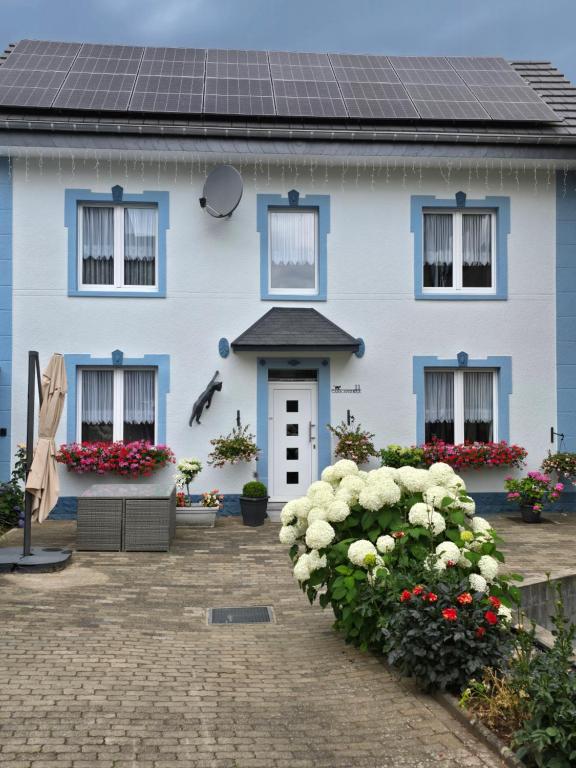 a blue and white house with flowers in front of it at Casa Andrea in Saint-Vith
