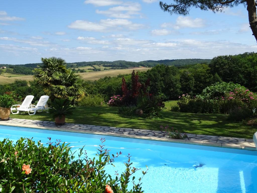 a swimming pool with a view of a garden at GITE Au Moulié in Blousson-Sérian