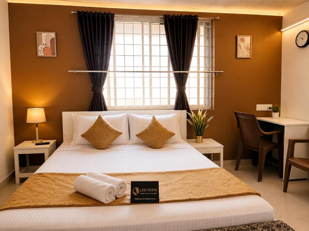 a bedroom with a bed with two towels on it at Leo Stays in Bangalore
