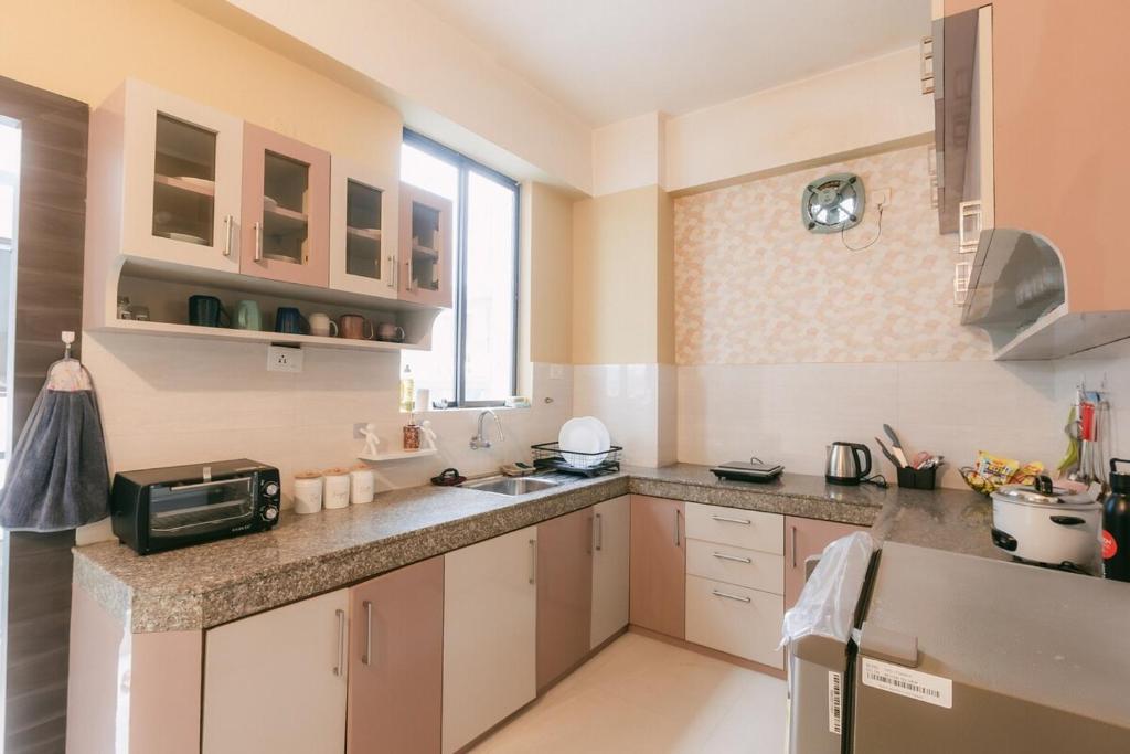 a kitchen with a sink and a microwave at CueCasa in Guwahati