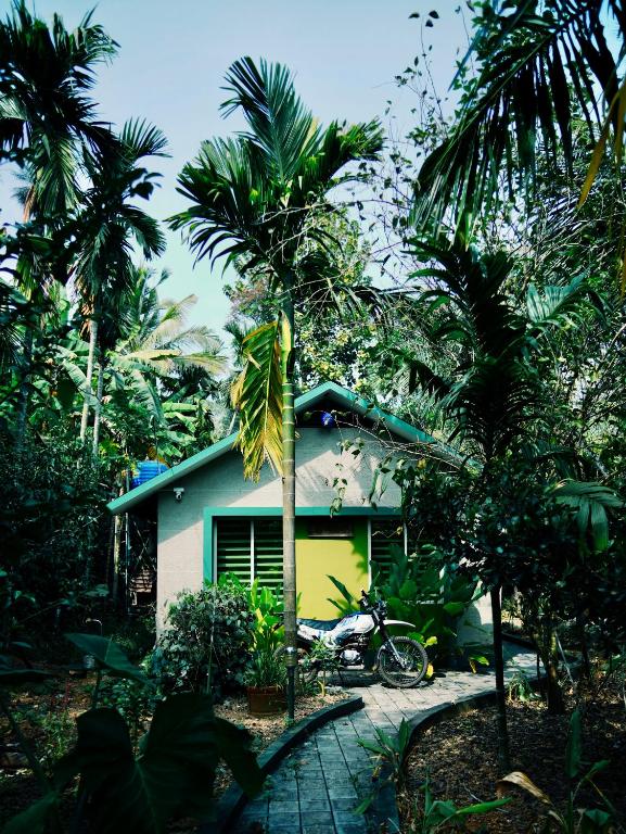 a house with a motorcycle parked in front of it at CatsClaw Inn in Talayolaparambu