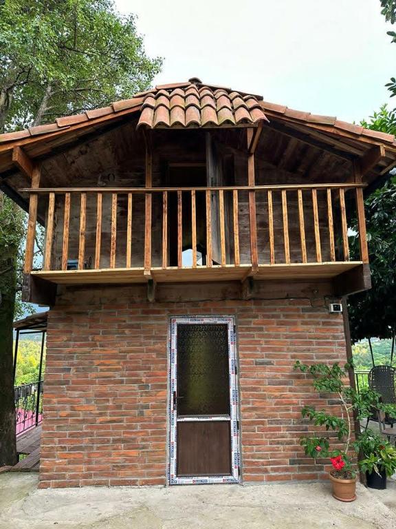 a small brick building with a balcony on top of it at კოტეჯი in Ts'ikhisdziri
