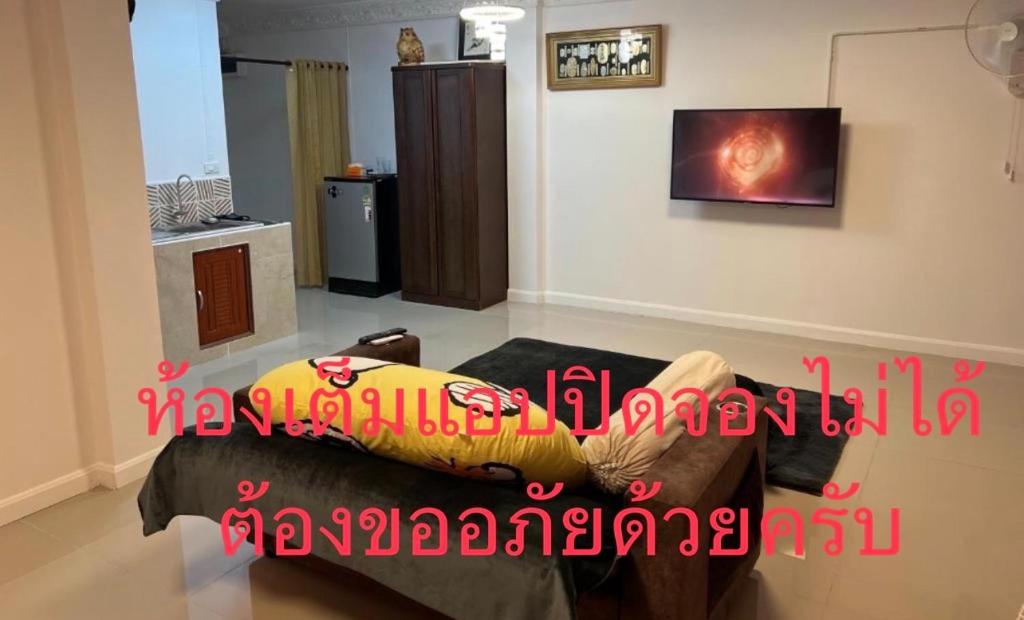 a living room with a couch with a pillow on it at เจริญคอนโดมิเนียม in Ban Nong Waeng
