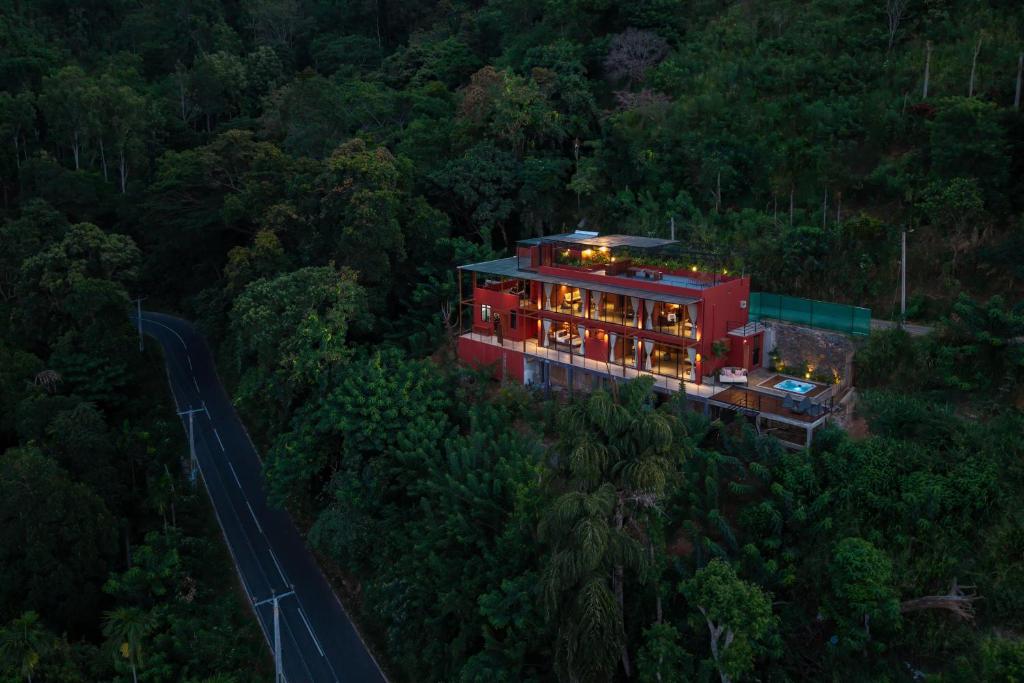 a red house in the middle of a forest at Villa Cavo - Beneath the Misty Peaks in Haputale