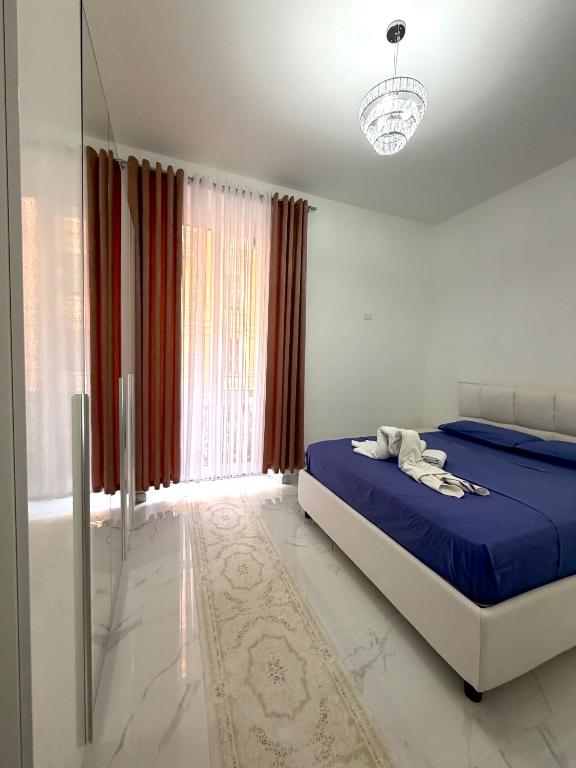 a bedroom with a bed with blue sheets and a window at Perla Azzurra in Savona