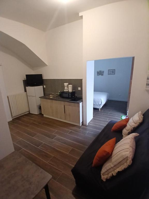 a living room with a couch and a kitchen at Joli t1 bis Drôme des collines in Saint-Vallier