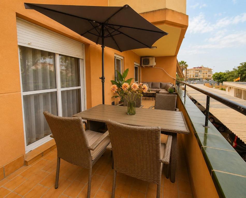 a wooden table with chairs and an umbrella on a balcony at BlueSabinillas in San Luis de Sabinillas