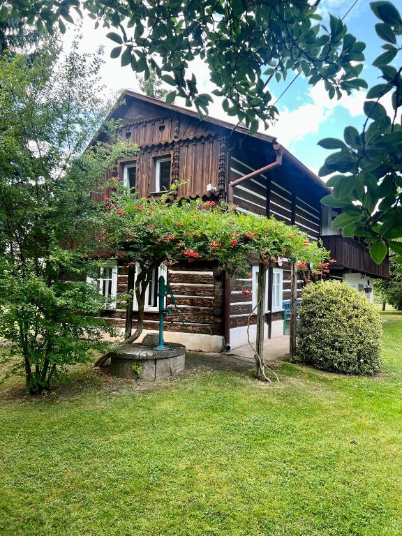 a house with a flower garden in front of it at Ubytování v Roubence in Modřišice