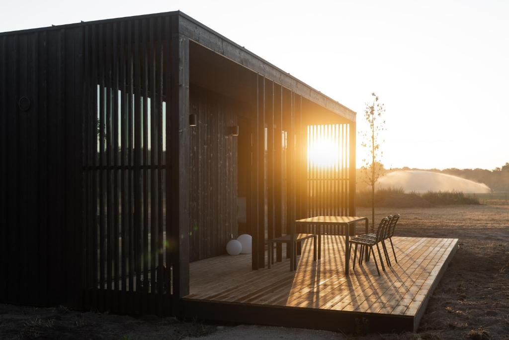 a building with a table and chairs on a deck at Eco by Nature - De Stilte - in Heythuysen