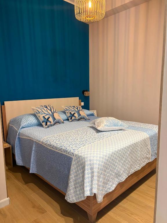 a bedroom with two beds with blue walls and a chandelier at Sciuri House in CTA