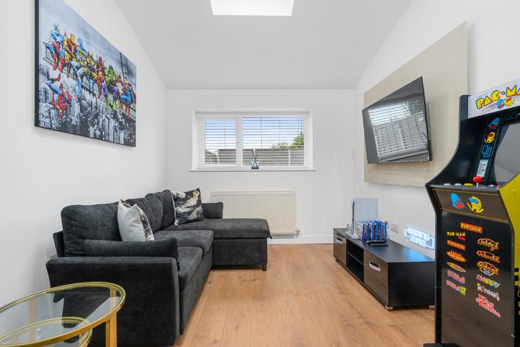 a living room with a couch and a video game at Private Double Room in Spacious House with Garden in Blackrod