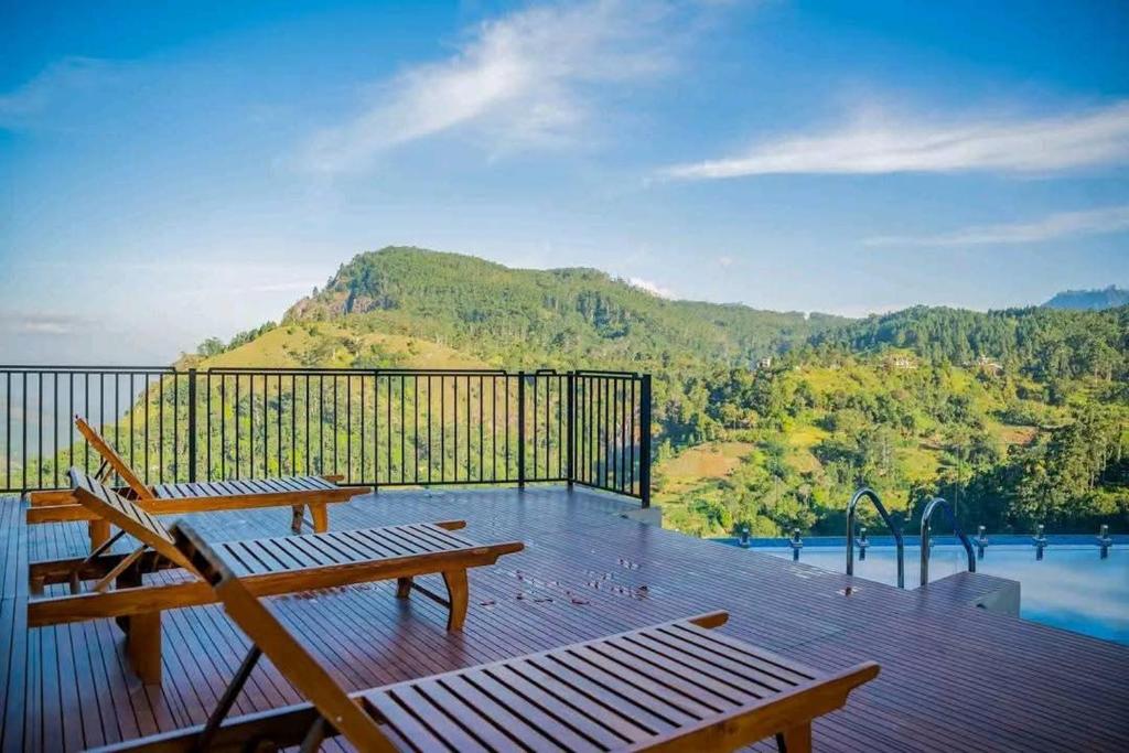 a balcony with two benches and a view of a mountain at Crystal springs mount face Hotel in Ella