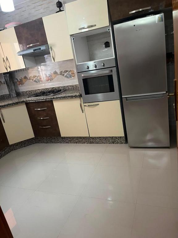 a kitchen with a stainless steel refrigerator and stove at Appartement proche toutes commodités in Berkane