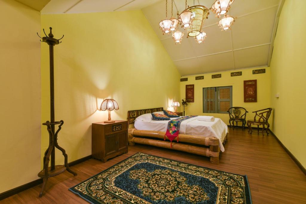 a bedroom with two beds and a lamp and a rug at Ohana House @ 15 Kuli in Melaka