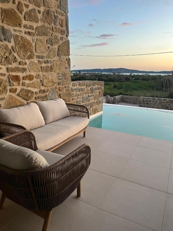 a patio with a couch and a swimming pool at Rea's Luxury Suite Gialova in Gialova