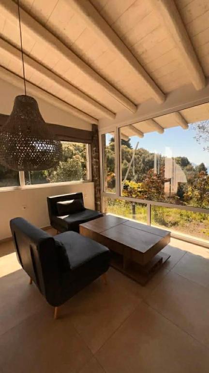 a living room with a table and a chair at Ellia Mirtiotissa Rooms in Glyfada