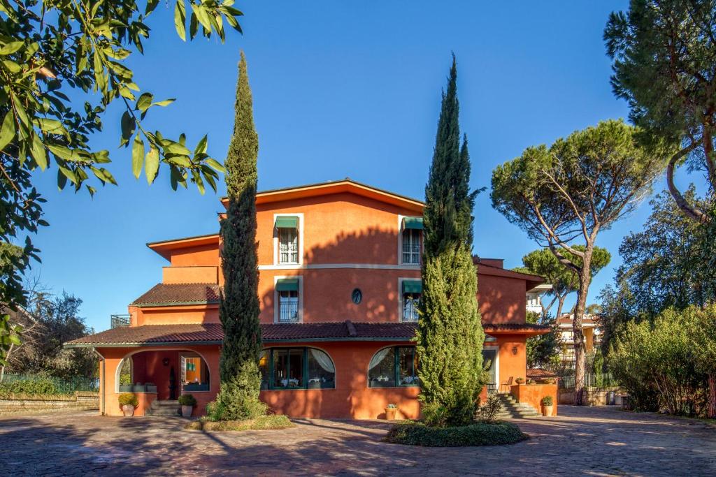 een oranje huis met bomen ervoor bij Resort La Rocchetta in La Giustiniana