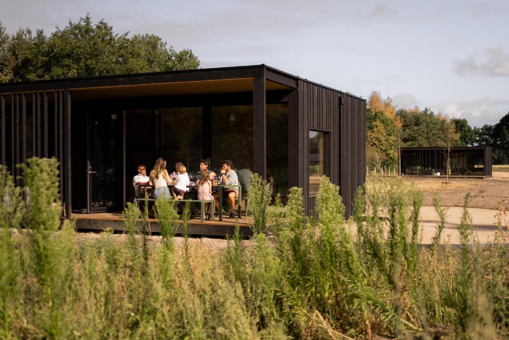 a group of people sitting in a black building at Eco by Nature - De Adem - in Heythuysen